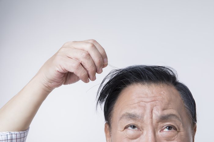 머리카락을 만지고 있는 남성